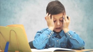 Mavi kot pantolon lu genç, genç, kot tişörtlü bir çocuk yazıyordu ve bir hata yaptı. Şimdi nasıl düzelteceğini bilmiyor..