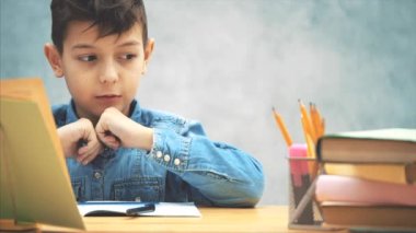 Pretty schoolboy bir bulmaca çözme, sayma, sonra bir hesap makinesi alarak.