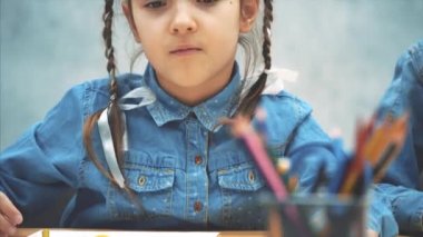 Pigtails ile Sevimli yaratıcı kız sepet ve çizim bir kalem ulaşan.
