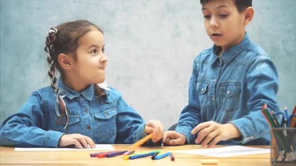 Hermano y hermana compartiendo marcadores de colores y empezando a dibujar . — Vídeos de Stock