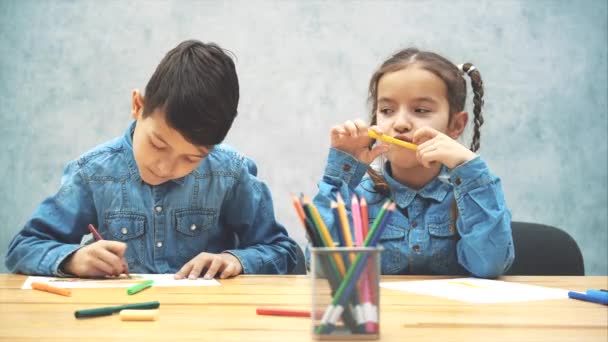 Niedlich inspiriert Bruder und Schwester zeichnen lernen. freches kleines Mädchen, das auf dem Ohr ihrer Brüder zeichnet. — Stockvideo