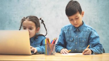 Güzel kız bilgisayar oyunu oynarken yer almaktadır, kardeşi çizim ve onu düzeltmek, oynamak için yardımcı.