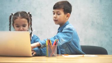 Güzel kız bilgisayar oyunu oynarken yer almaktadır, kardeşi çizim ve onu düzeltmek, oynamak için yardımcı.