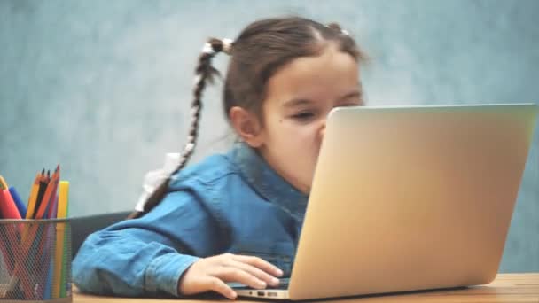 Szép lány Pigtailek lelkesen játszik a játék a laptop. — Stock videók