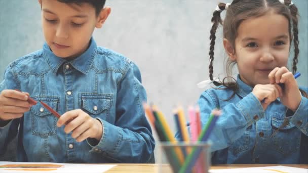 Ernte-Video von Schulkindern zeichnen, hübsches Mädchen nimmt grünen Bleistift schneller als ihr Bruder. — Stockvideo