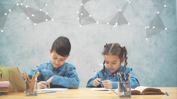 Skolbarn, bror och syster, sitter vid bordet, skriver. Sedan pekar fingrarna upp som om de kom upp med en utmärkt idé. — Stockvideo