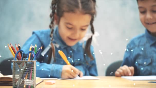 Wazig schoolkinderen, broer en zus, zittend aan tafel, schrijven, glimlachend. Abstracte geometrische voorhoede. — Stockvideo