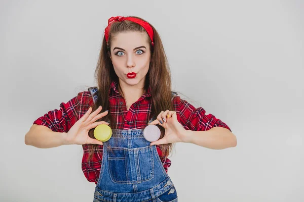 Ανόητο νεαρό παιχνιδιάρικο κορίτσι κρατά δύο αμυγδαλωτά στη θέση των κουμπιών του τζιν της. Εκφραστικό βλέμμα. Πάπια. — Φωτογραφία Αρχείου