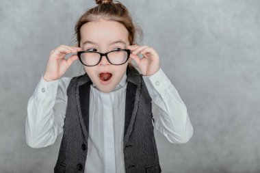 Gri bir geçmişi olan küçük bir iş kadını. Bu yakın çekim sırasında gözlük takıyor..