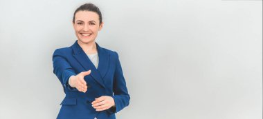 Güzel öğretmen ayakta duruyor, sanki biriyle tokalaşmak istercesine ellerini kameraya uzatıyor, selamlıyor..