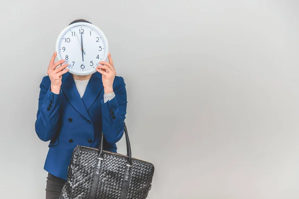 El final de la jornada laboral. Es hora de ir a casa. El profesor se esconde detrás del reloj blanco . —  Fotos de Stock