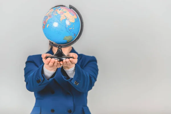 Blurred funny geography teacher hiding her head behind the globe. Focus on the forefront.