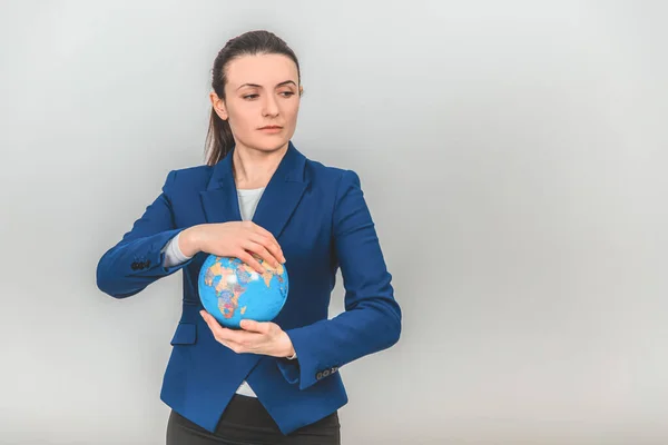 Young geography teacher holding a globe, looking to the side. — Stock Photo, Image