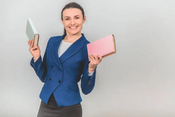 Cute female teacher holding two colorful books, posing and smiling. — Stock Photo, Image