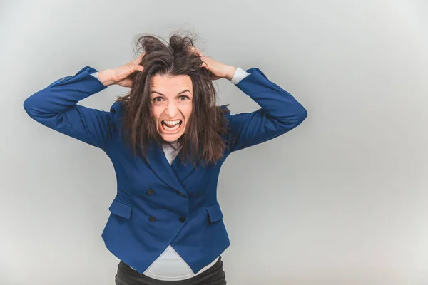 Young teacher bearing fingers in her hair, making in tousled, screaming, looking out of mind.