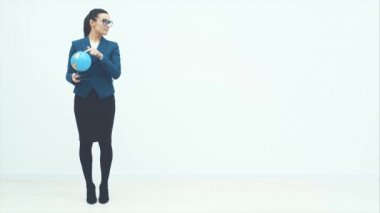 Dünya genç bir iş kadınının elinde. Beyaz bir arkaplanda sahneleniyor. Sevinçle dans etmek. Şık bir gülümseme.