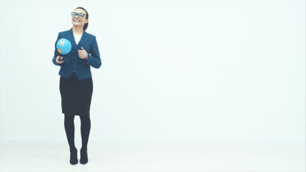 Joven buen maestro sobre un fondo blanco. Sostiene el globo en sus manos. Sonríe y cuenta historias. Vestido con gafas . — Vídeos de Stock