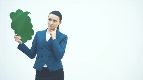 Una hermosa maestra joven tiene una ventana emergente verde. Apuntando y sonriendo. Profesor de pie sobre un fondo blanco . — Vídeos de Stock