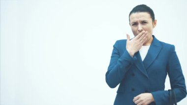 Uyuyan öğretmen beyaz bir zeminde duruyor. Beyaz yuvarlak bir saat tutuyor. Kahve iç. Yakın plan..