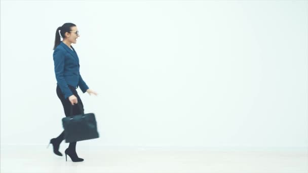 Young beautiful business woman model on white background. The bag runs on a white background. Happy and energetic woman. — Stock Video