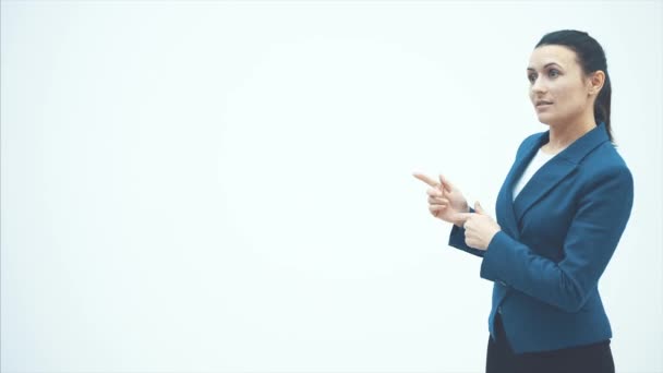 Mladá dobře vypadající učitelka paní ukazující prstem třídu. Na bílém pozadí. Oblečená a modrá bunda. — Stock video