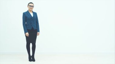 Ciddi, kendine güvenen bir öğretmen beyaz bir arkaplanda duruyor. Topuklu. Kameraya bak. Çok ciddi..