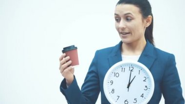 Beyaz arka planda duran iyi bir öğretmen. Beyaz bir saat ve kahve tutuyor. İçtenlikle gülümseyin..