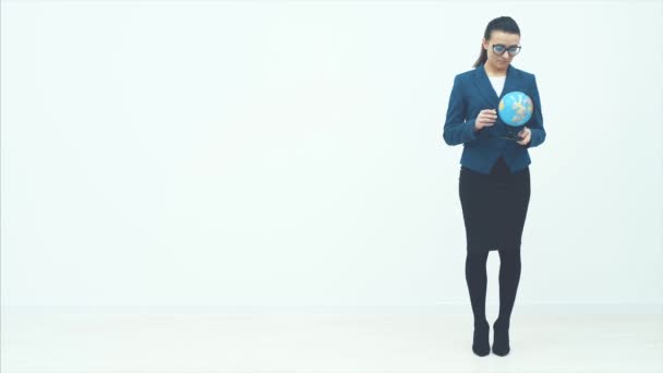 Jeune femme d'affaires debout sur un fond blanc. Dans les mains du globe tient et agite sa tête et tord le globe . — Video