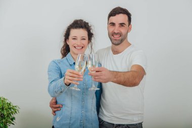 Yeni dairelerine taşınmalarını kutlamak için şampanya kadehleriyle dikilen büyüleyici bir çiftin bulanık görüntüsü..