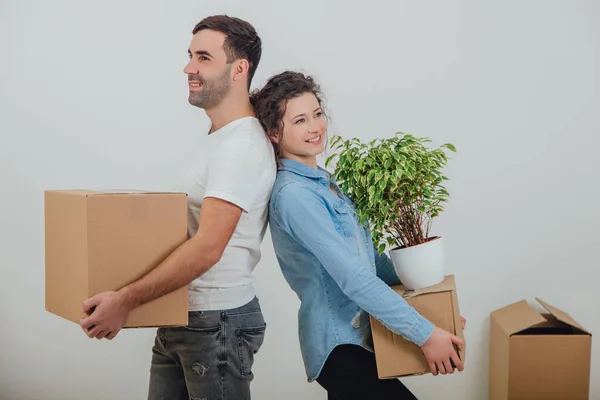 Happy wife and husband holding carton boxes, standing back to back, smiling extremely satisfied to move into new apartment. — Stock Photo, Image