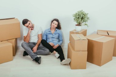 Yeni eve taşınma süreci çok yorucu. Sevgili genç çift, karı koca yeni dairelerinde karton kutuların arasında oturuyorlar..