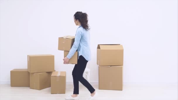Strong woman is carring large moving boxes, full of items, isolated on white background. Copy space. Animation. Action. 4K. — ストック動画