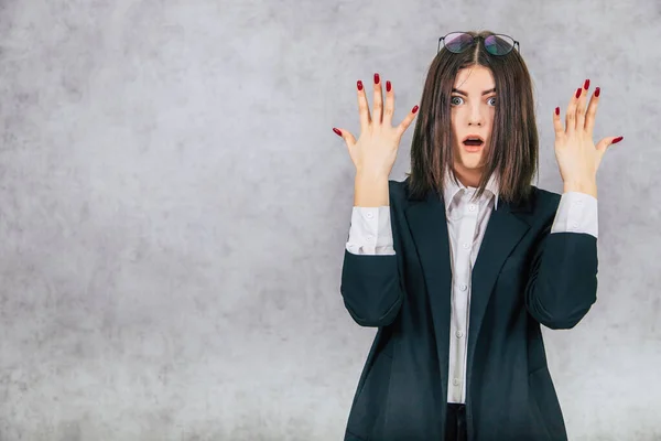 Scared businesslady with glasses on the forehead, raising her hands looking with eyes widely opened. — Stock Photo, Image