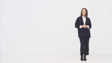 Uzun boylu, çekici, takım elbiseli, gülümseyen bir iş kadını elleri katlanmış, neşeyle gülümsüyor, poz veriyor..