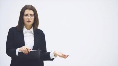 Takım elbiseli esinlenilmiş iş kadını elinde kağıt tutucuyla duruyor, konuşuyor, bir şeyler sunuyor, umutsuzca tartışıyorlar..