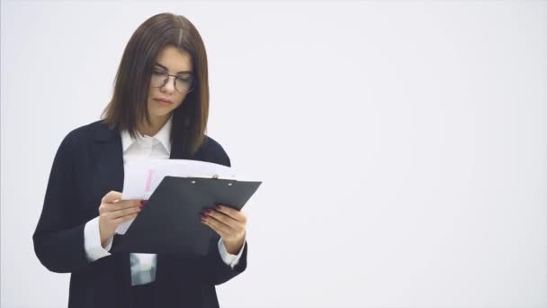 Piękna bizneswoman w czarnym garniturze stojąca z papierowym uchwytem w rękach, czytająca, znajdująca błędy, patrząca gniewnie z nieporozumieniem na twarzy. — Wideo stockowe
