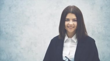 Güzel bir genç kız alkışlıyor, poz veriyor ve gülümsüyor.