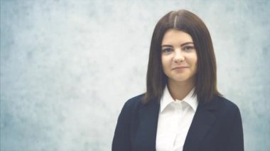 Çekici iş kadını kameraya bakıyor, poz veriyor ve gülümsüyor..