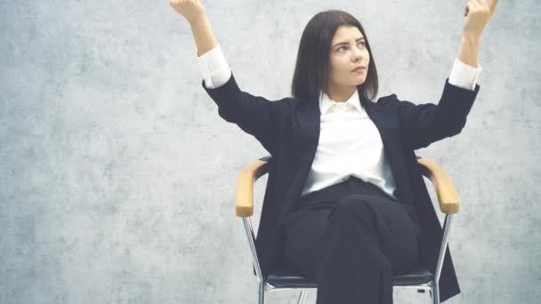 Feliz joven empresaria sentada en la silla como un jefe, sus manos levantadas, llamando a alguien, sonriendo . — Vídeos de Stock