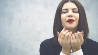 Siyah takım elbiseli, gülümseyen genç, çekici iş kadını ayakta, poz veriyor, hava öpücüğü veriyor, mutlu bir şekilde gülümsüyor..