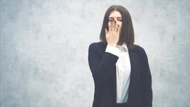 Jeune femme d'affaires fatiguée en costume noir bâillant, regardant l'horloge, et allant dormir . — Video