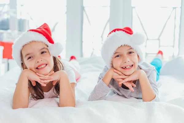 Ritratto ravvicinato di una bambina e un ragazzo nella mattina di Natale sullo sfondo bianco di un albero di Capodanno . — Foto Stock