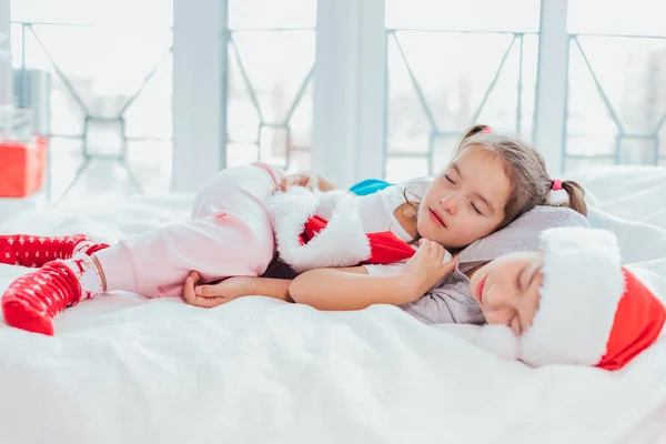 Dos niños exhaustos están durmiendo, abrazándose dulcemente después de la fiesta de año nuevo . —  Fotos de Stock