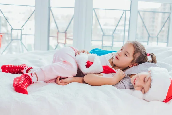 Dos niños exhaustos están durmiendo, abrazándose dulcemente después de la fiesta de año nuevo . —  Fotos de Stock