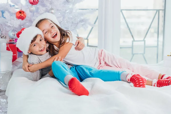 행복하게 웃는 두 어린 소년 과 소녀, 남동생 과 여동생 크리스마스 트리 근처에서 아침에 즐겁게 놀고 있습니다.. — 스톡 사진