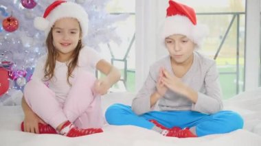 Noel 'de evde yatak odasında yoga yapan küçük kardeşlerin ilginç bir videosu..