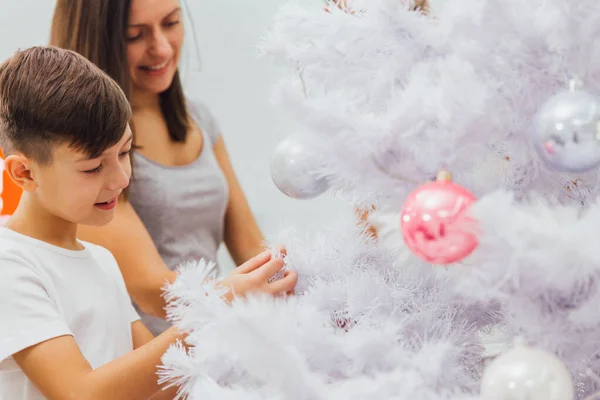 Feliz jovem mãe e seu filho em casa com uma árvore de Natal — Fotografia de Stock