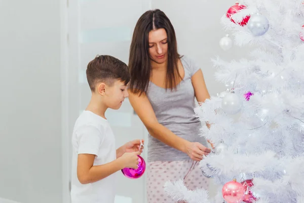 Feliz jovem mãe e seu filho em casa com uma árvore de Natal — Fotografia de Stock
