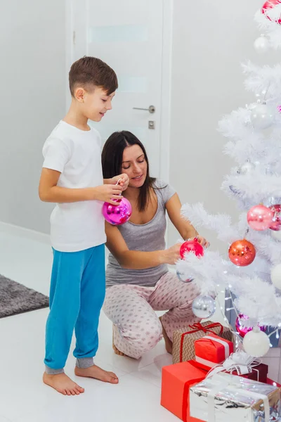 크리스마스 트리를 장식 하는 그의 엄마를 돕는 소년 — 스톡 사진