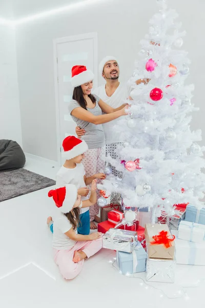 Giovane bella famiglia decora l'albero di Natale — Foto Stock